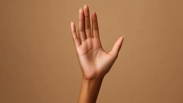 Open Palm with Long, Clear Nails Against a Tan Background photo