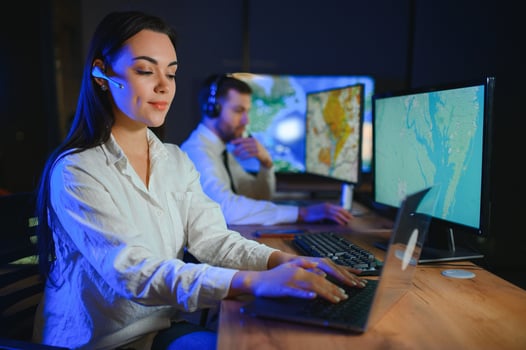 Center of dispatching maintenance. Portrait of cheerful woman and man working via headset microphone while sitting on navigation controller board photo