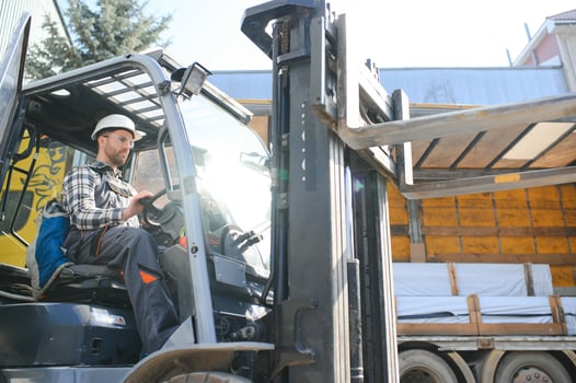 Portrait of professional forklift driver in factory's warehouse photo