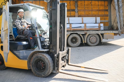 A man on a forklift works in a large warehouse, unloads bags of raw materials photo