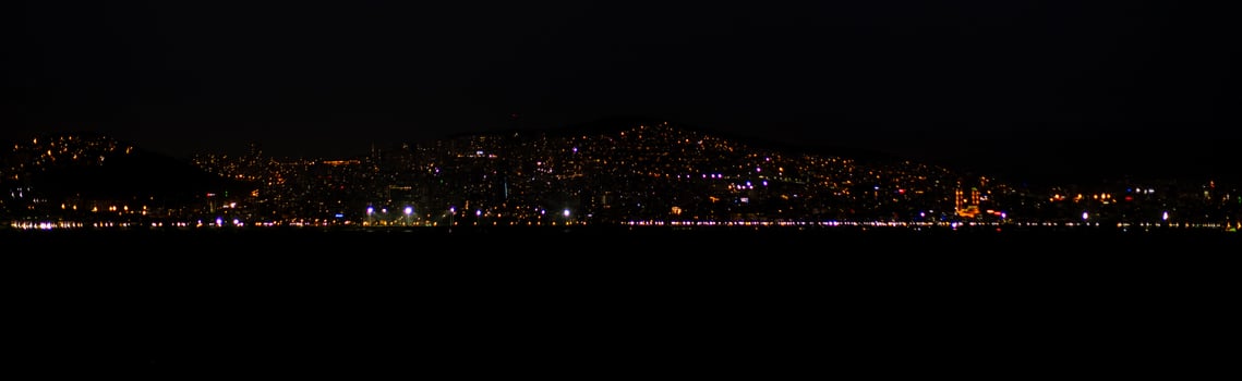 The skyline of Istanbul sparkles at night with countless lights reflecting photo