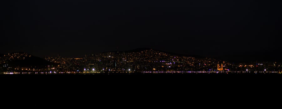 The skyline of Istanbul glows at night, showcasing bright lights over the water photo