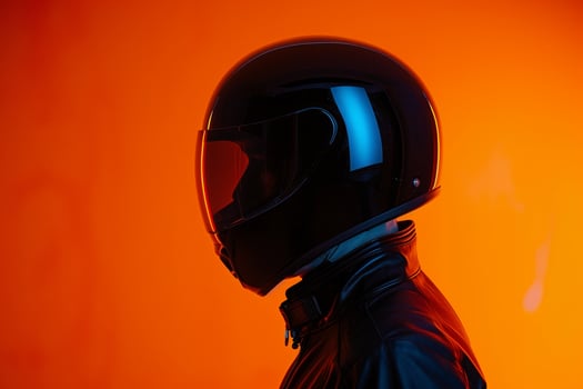 Matte Black Fashion Helmet Male Model with Neon Orange Background Chic and Stylish Lifestyle portrait for Modern Apparel photo