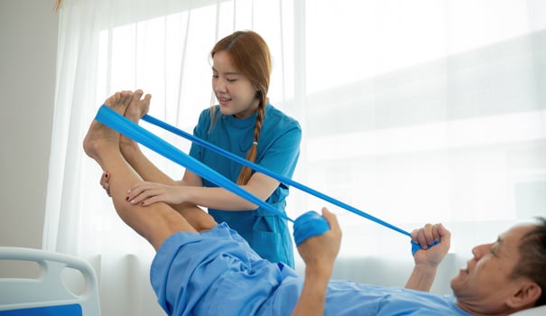 Elderly Patient Receiving Physical Therapy from Young Female Therapist Using Resistance Bands in a Bright Medical Facility photo