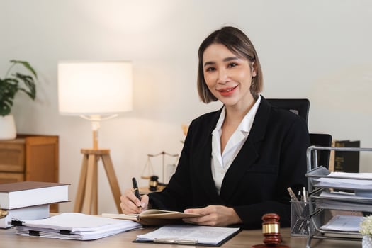 Professional Female Lawyer Reviewing Legal Documents in Modern Office Setting for Lawsuit Preparation photo
