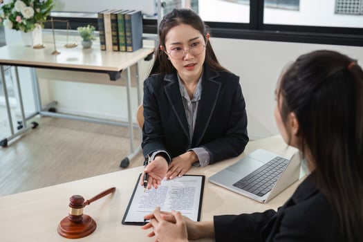Young Lawyer Providing Professional Legal Advice to a Young Woman in a Modern Office Setting photo