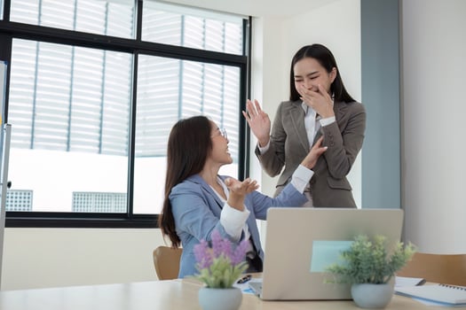Two Young Accountant Celebrating Success in Modern Office Environment with Laptops and Documents photo