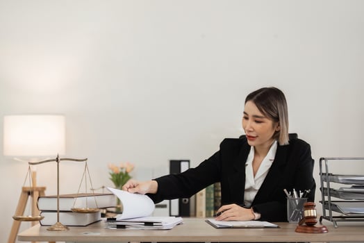 Professional Female Lawyer Working at Desk in Modern Office with Legal Documents and Scales of Justice photo