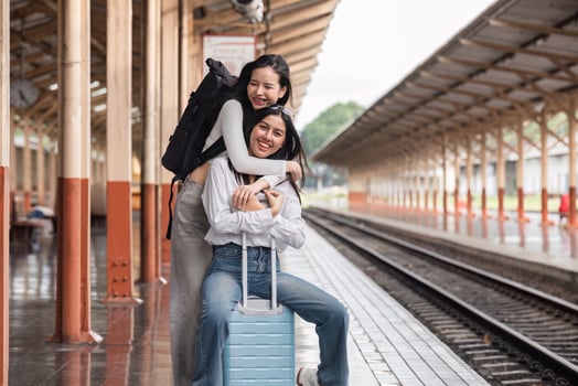 LGBT Lesbian Couple Embracing and Waiting for Train at Train Station, Travel Adventure, Love, and Journey Concept photo