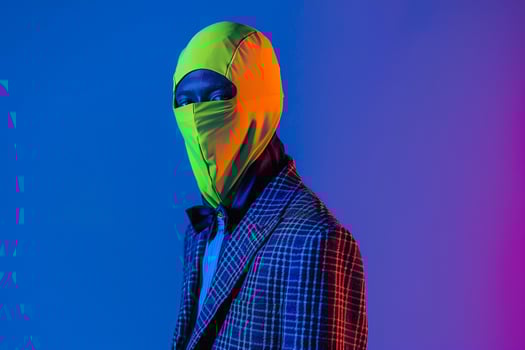 Fashion Model in Casual Blazer with Neon Yellow Ski Mask and Neon Blue Background High end Fashion portrait photo