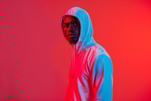 Vibrant Male Fashion Model in Trendy Tracksuit with Neon Coral Background Combining Contemporary Style with Bold Colors photo