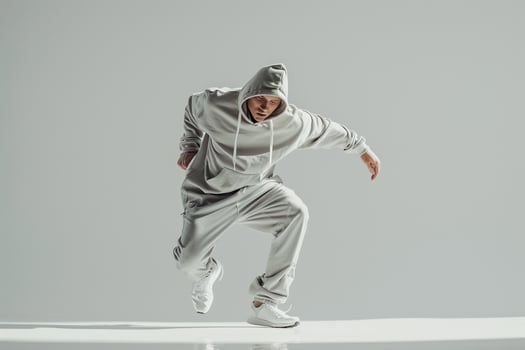 Trendy male model in a futuristic white tracksuit delivering a chic high fashion portrait with a contemporary lifestyle backdrop photo