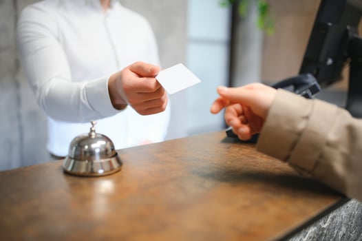 Close up of hand guest takes room key at check-in desk of the hotel. Hotel concept photo
