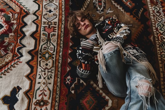 Males fashion in a fringed jacket with a vintage rug background showcasing a classic and retro lifestyle in a modern portrait photo