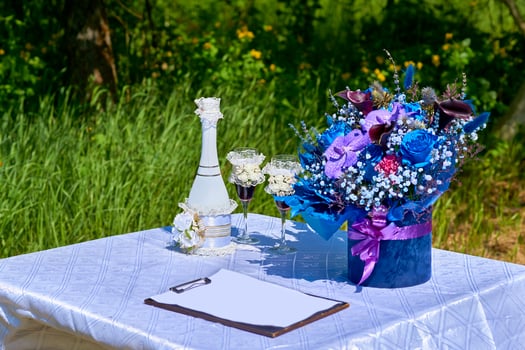 Wedding accessories and champagne with glasses for marriage in summer park photo