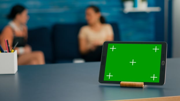 Laptop computer with mock up green screen chroma key display it is used for online connection standing on office table. Women talking about isolated pc in living room background photo