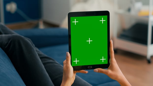 Close up of business woman hands holding tablet computer with mock up green screen chroma key display sitting on sofa. Freelancer using isolated touchscreen device for social networks browsing photo