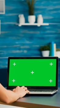 Freelancer woman searching business advertising using isolated pc standing in home office studio. Caucasian woman working with laptop computer with mock up green screen chroma key photo