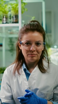 Pov of chemist woman in white coat analyzing with biologists team during online videocall meeting while sitting in microbiology lab. Specialist researching genetic mutation developing dna test photo