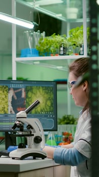 Biochemistry doctor examining chemical test using microscope for genetic researcher. Biologist specialist discovery organic gmo plants while working in microbiology food laboratory photo