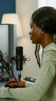 Portrait of concentrated african gamer looking at camera smiling, playing online space shooter game for gaming tournament. Cyber performing on powerful pc with RGB keybord streaming videogames photo