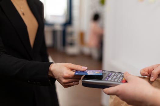 Close up of businesswoman holding plastic credit card in hand, paying for food delivery in company office. Using contactless pay for takeaway food. Bringing tasty meal. photo