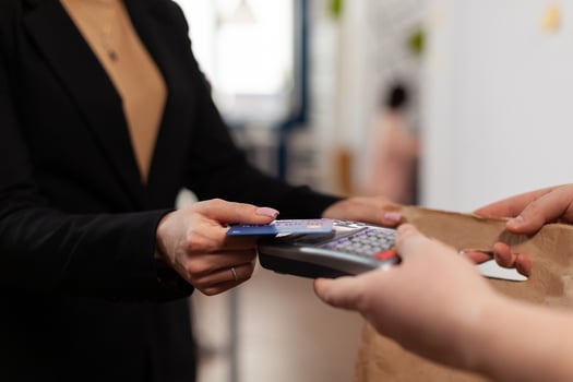 Close up of businesswoman holding plastic credit card in hand, paying for food delivery in company office. Using contactless pay for takeaway food. . Bringing tasty meal. photo