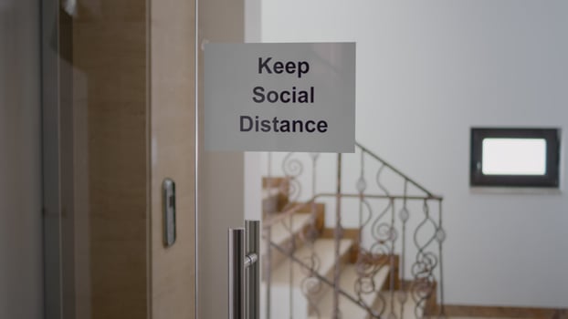 Glass office dor with keep social distance poster on it, modern office stairs duting covid 19 coronavirus pandemic, global economic crisis photo
