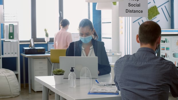 Business team with face masks working in company office taking precaution to mantain safety measures to avoid coronavirus infection. Collegues respecting social distancing during covid19 quarantine photo