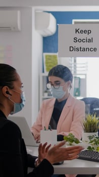 Coworkers wearing medical face masks to prevent infection with coronavirus while working in office company. Business woman talking with her team during online communication meeting photo