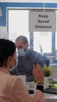 Businesswoman having online videocall meeting, disscusing about communication project in new normal company office. Team wearing face masks mantain social distance during coronavirus pandemic photo