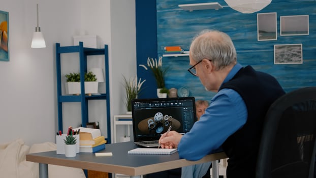 Senior remote man architect working on modern cad program analysing gears design. Industrial old engineer studying prototype idea on laptop computer showing cad software on device display photo
