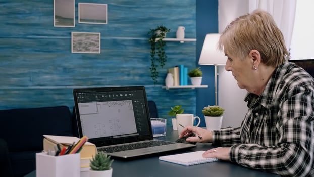 Middle aged woman engineer working with architectural plans, cad software on laptop computer. Designer using digital arhitecture blueprints of buildings working overtime, creating and studying photo