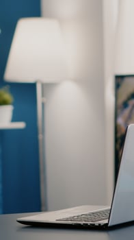 Empty workplace home office with modern design and laptop placed on desk. Living room with nobody in it, place of work, workspace concept, pretty simple modern decor of cozy apartment with television photo