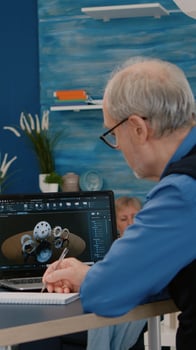 Senior remote man architect working on modern cad program analysing gears design. Industrial old engineer studying prototype idea on laptop computer showing cad software on device display photo
