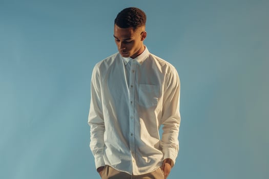 Fashionable male model in a long sleeve shirt with an ice blue background offering a modern portrait that highlights contemporary style with a cool fresh appeal photo