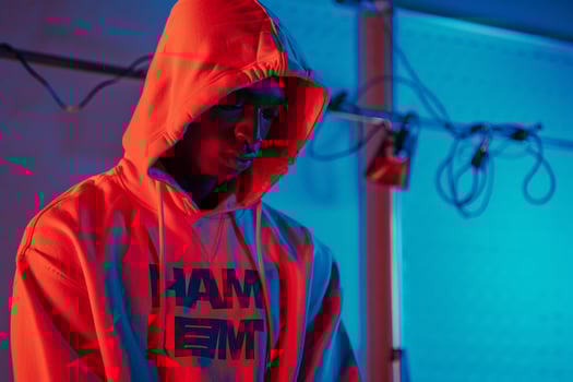 Handsome male model in hoodie electric blue background capturing contemporary urban fashion with a trendy lifestyle portrait photo