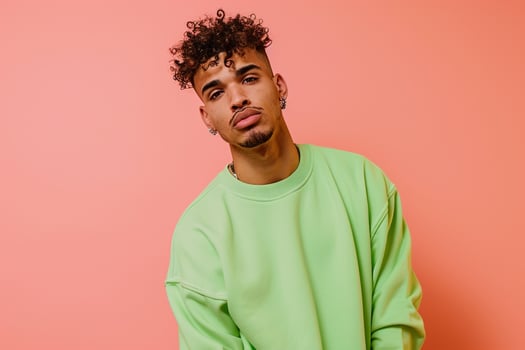 Youthful and Trendy Male Fashion Model in Bright Green Sweatshirt with Soft peach Background Highlighting Modern and Contemporary Style photo