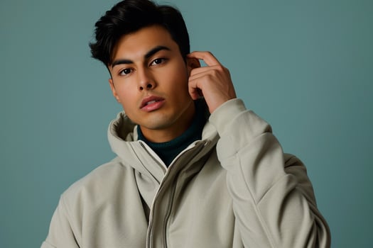 Trendy male model in a zip up jacket with a gray blue background showcasing a stylish lifestyle and modern fashion portrait photo