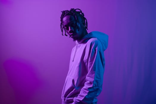 Deep Violet Background with Hoodie Clad Male Lifestyle portrait emphasizing Trendy Fashion and Comfortable Wear photo
