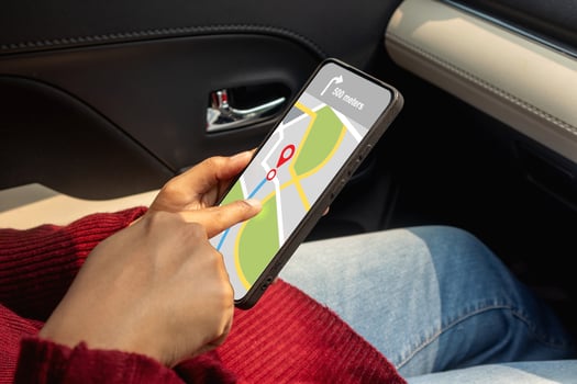 Hand of woman in a car holding a mobile phone with a GPS navigation map photo