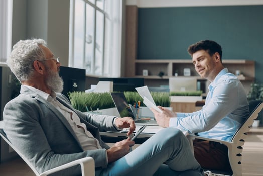 Two confident businessmen communicating while working in the office together photo