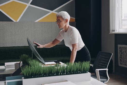 Confident senior businesswoman using touchscreen monitor while working in office photo