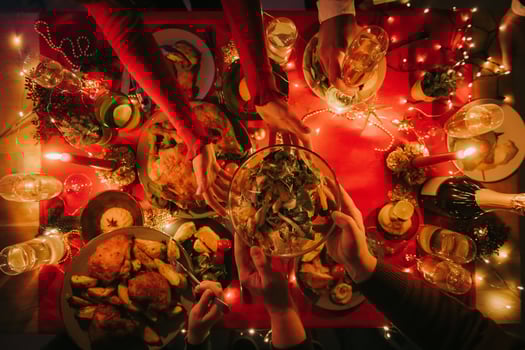 Top view of people enjoying variety of Christmas dishes while having holiday dinner at the decorated table photo