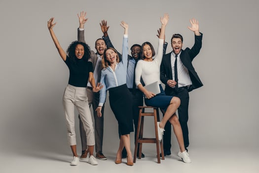 Joyful young business team in formalwear gesturing while standing on beige background photo