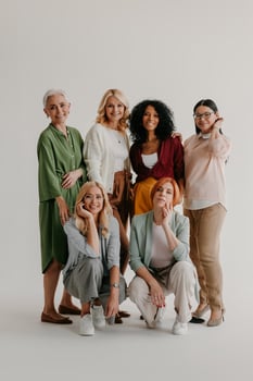 Multi-ethnic group of mature women bonding and smiling against grey background photo