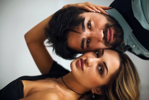 Stylish young ethnic couple embracing against light gray wall photo