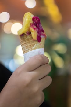 Close up hand of a person holding an ice cream cone with blurred background photo