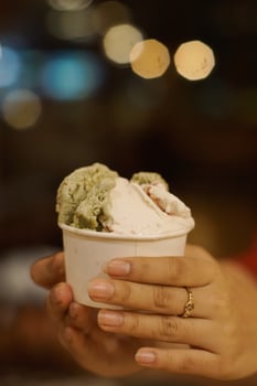 Close up hand of a person holding a cup of ice cream with blurred background photo