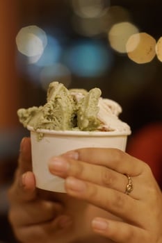 Close up hand of a person holding a cup of ice cream with blurred background photo